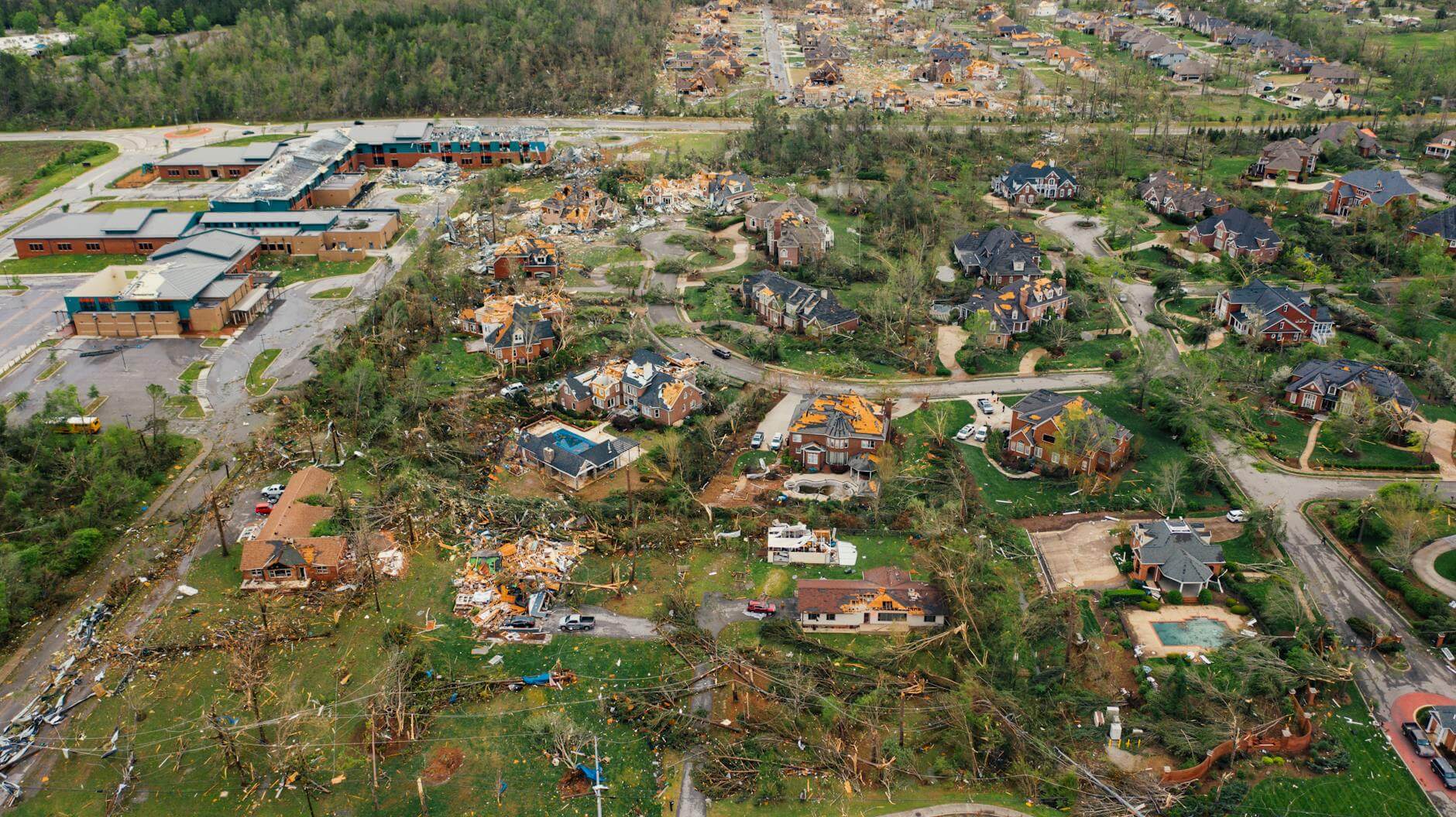 village houses with damaged roofs and uprooted trees