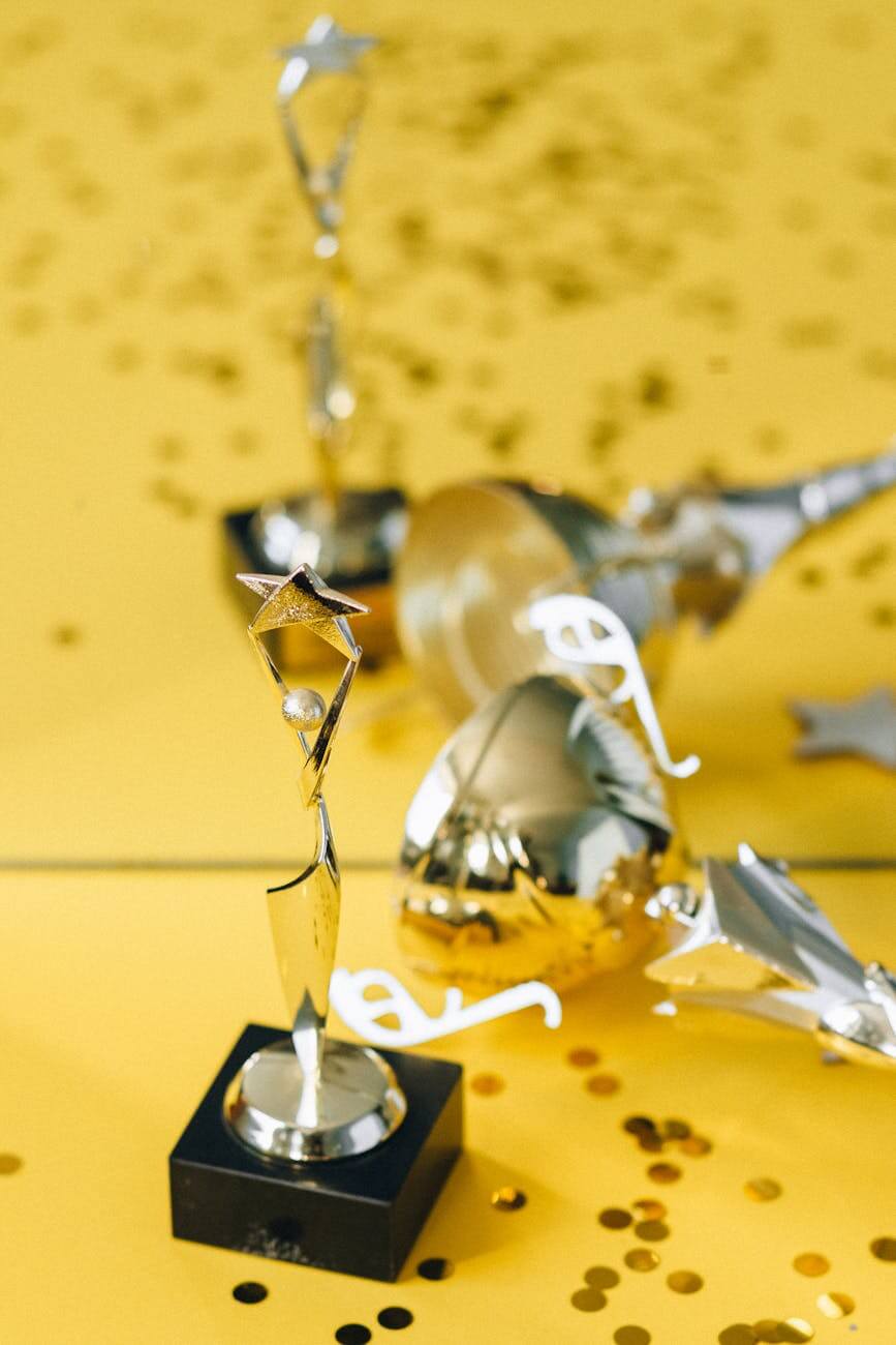 golden statuette and trophy beside mirror