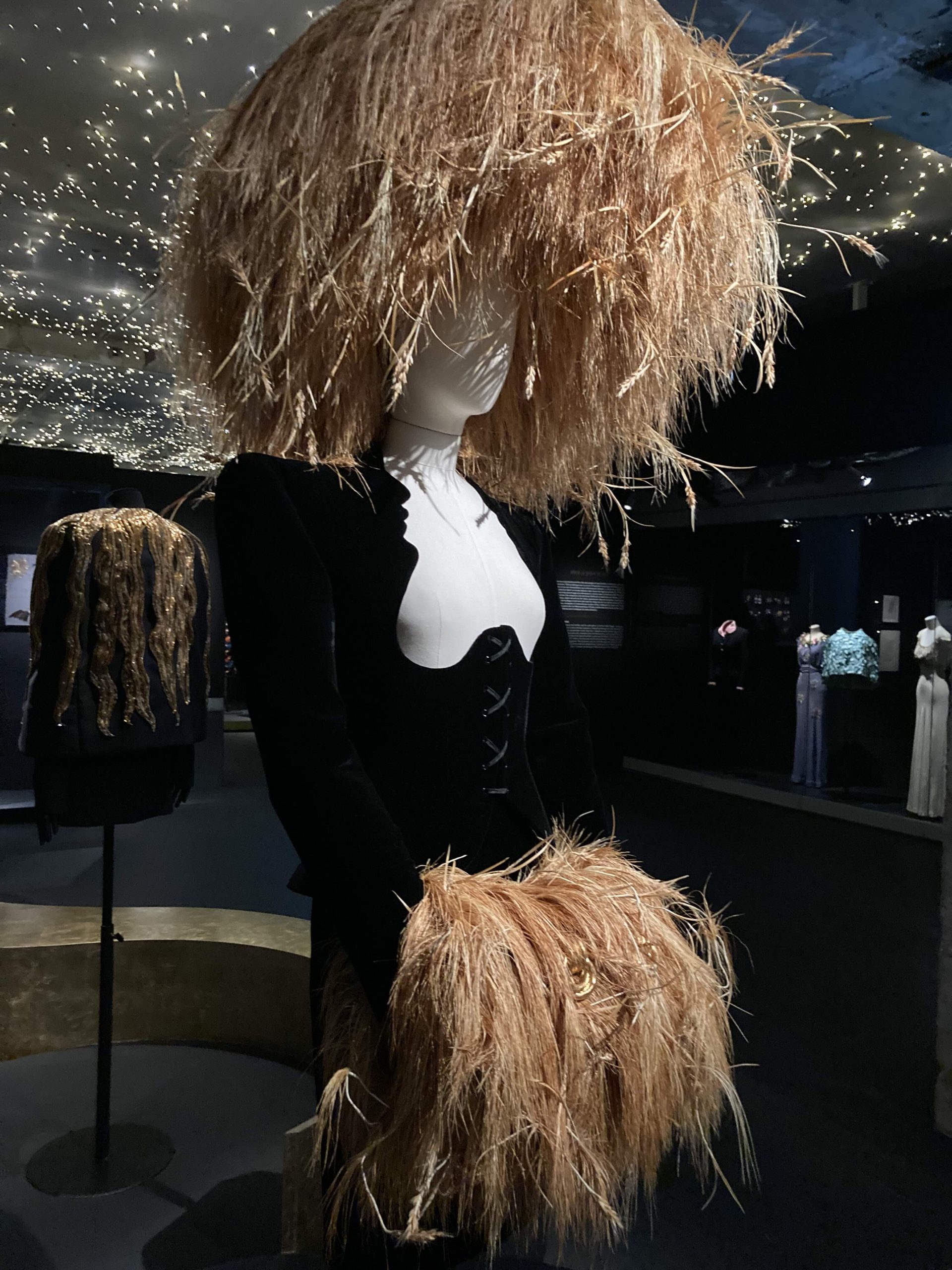 A mannequin with a wheat grass had and gloves