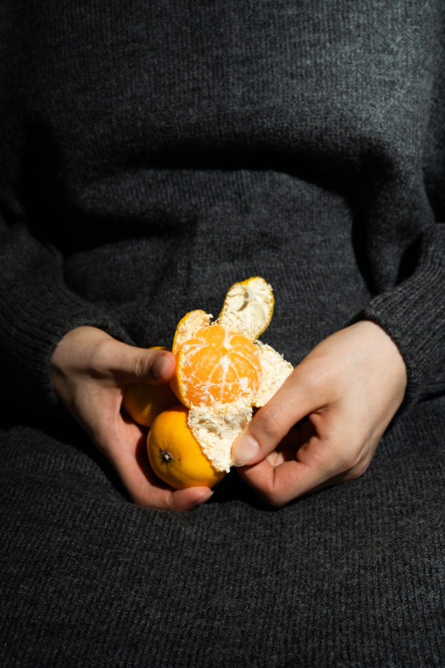 close up of hands peeling fresh tangerine