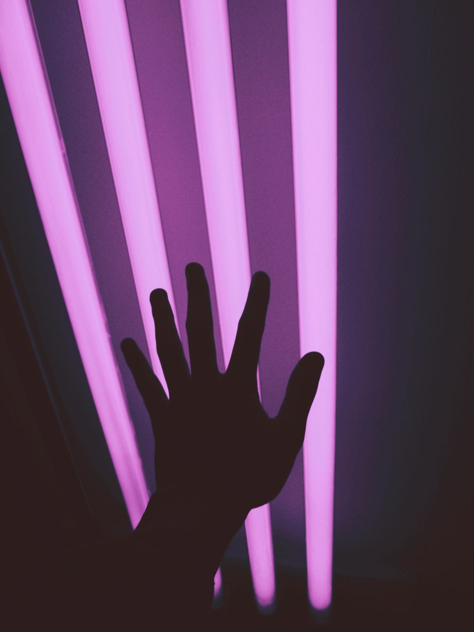 a silhouette of a hand in a dark room