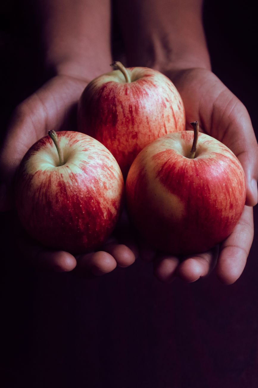 person holding red apple fruits